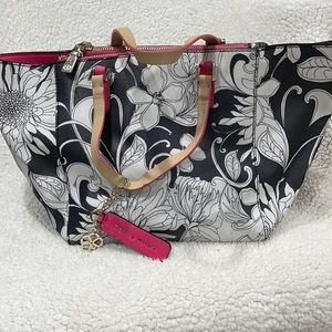 Trina Turk black and white purse with pink trim.
